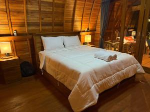 a bedroom with a bed with a towel on it at Qchen Cuan Cabin Amed in Amed