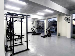 a gym with several tread machines in a room at BH UrbanSky Condo in Mactan