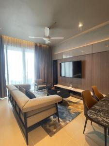 a living room with a couch and a flat screen tv at Antara Genting by Enigma 2BR, Mid Floor in Genting Highlands