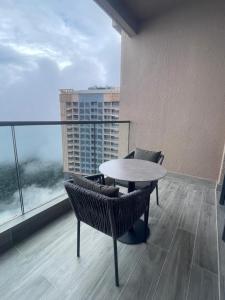 a balcony with a table and chairs on a building at Antara Genting by Enigma 2BR, Mid Floor in Genting Highlands
