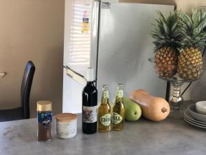 Una mesa con botellas de vino y fruta encima. en Airport Reading Room Rest, en Perth
