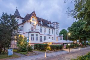 a large white building with a black roof at Hotel-Pension Seeblick in Kühlungsborn