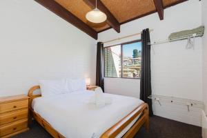 Alpha Centauri - 8 - 39 Gippsland Street في جيندابين: غرفة نوم بسرير أبيض ونافذة