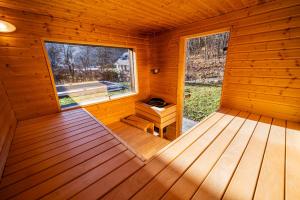 an empty interior of a wooden cabin with a window at Ubytování za Řekou in Hořejší Vrchlabí