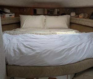 a large bed with white sheets and pillows at Luxury Yacht Stay in Port Antonio, Exclusive Dockside Escape in Port Antonio