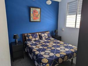 a blue bedroom with a bed and a picture on the wall at Espacio Santa Bárbara, Zona Colonial in Santo Domingo