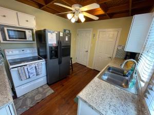 a kitchen with a refrigerator and a stove and a sink at Seahorse Bungalow in St. Pete Beach