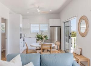 a living room with a blue couch and a table at The Sand Box in Kingscliff