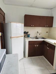 a kitchen with brown cabinets and a white refrigerator at Casa Little Italy in Boquerón +8 photos