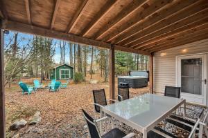patio ze stołem, krzesłami i sprzętem do grillowania w obiekcie Cozy Family Chalet With Hot Tub, Fire Pit, Game Room w mieście Blakeslee