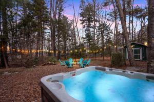 wanna z hydromasażem na dziedzińcu z krzesłami i stołem w obiekcie Cozy Family Chalet With Hot Tub, Fire Pit, Game Room w mieście Blakeslee