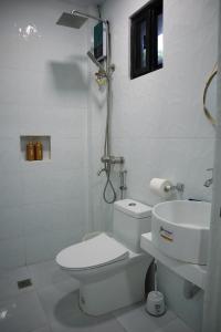 un bagno bianco con un water e un lavandino di Jmt Star's Inn a General Luna