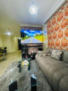 a living room with a couch and a flat screen tv at Résidence TPM in Casablanca