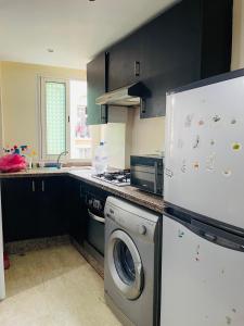 a kitchen with a washing machine and a refrigerator at Résidence TPM in Casablanca