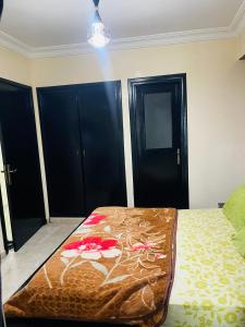 a bedroom with a bed and two black doors at Résidence TPM in Casablanca