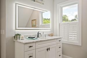 un bagno bianco con lavandino e specchio di River Lofts - Onyx & Catawba Cottages a Hickory Altre 118 foto
