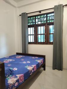 una camera da letto con un letto e una finestra di Galhena Apartments a Tangalle Altre 77 foto