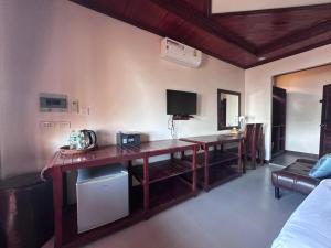 a living room with a desk and a tv at golden hotel dondet in Don Det