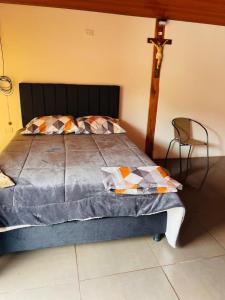 a bedroom with a bed with a cross on the wall at Cabaña Brisa Andina in Tibaná