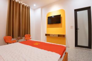 ein Schlafzimmer mit einem Bett und einem Fernseher an der Wand in der Unterkunft Khách sạn Hera Hotel in Hà Ðông + 53 Fotos