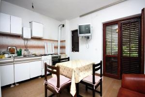 una cucina con tavolo, sedie e televisione di Apartments and rooms by the sea Sobra, Mljet - 4888 a Sobra Altre 26 foto