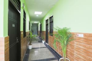 korytarz z doniczkami w budynku w obiekcie Capital O A-one w mieście Manesar +25 zdjęć