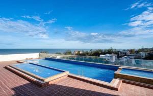 a swimming pool with a view of the ocean at CSJ TOWER VŨNG TÀU - CĂN HỘ DU LỊCH NGHỈ DƯỠNG CẠNH BÃI BIỂN Po's HOMESTAY in Vung Tau