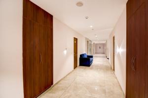 Gomti NagarにあるSuper Townhouse Vibhuti Khand Gomti Nagar Formerly Pratham Innの建物内の青い椅子が置かれた長い廊下