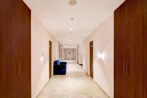 Gomti NagarにあるSuper Townhouse Vibhuti Khand Gomti Nagar Formerly Pratham Innの青いソファ付廊下