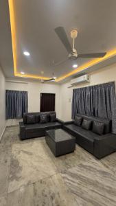 ein Wohnzimmer mit zwei schwarzen Sofas und einem Tisch in der Unterkunft Blue moon in Hyderabad + 1 Foto