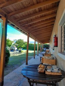 einen hölzernen Picknicktisch unter einer Markise auf einer Terrasse in der Unterkunft Posada L'Agustina in Nono