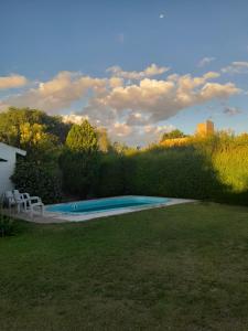 ein Pool in einem Garten neben einer Hecke in der Unterkunft Posada L'Agustina in Nono
