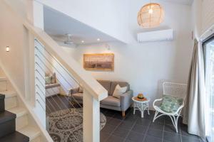 Bayshore Bungalow 12 - Oceanstays في خليج بايرون: غرفة معيشة بها درج وأريكة