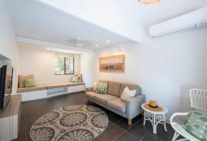 Bayshore Bungalow 12 - Oceanstays في خليج بايرون: غرفة معيشة بها أريكة وطاولة