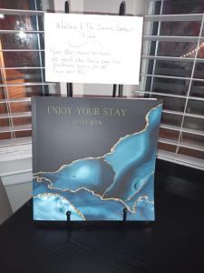 a sign that says enjoy your stay catch book on a table at The Serene Uptown Flat in Charlotte