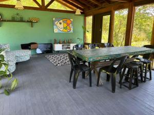 a dining room with a green table and chairs at Pousada Sonho do Vale in Praia do Rosa