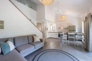 Bayshore Bungalow 13 - Oceanstays في خليج بايرون: غرفة معيشة مع أريكة ومطبخ