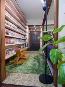 a room with a library with a chair and books at 漫画のある家 in Wada