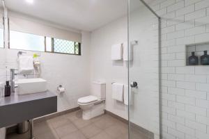 Bayshore Bungalow 13 - Oceanstays في خليج بايرون: حمام مزود بمرحاض ودش زجاجي