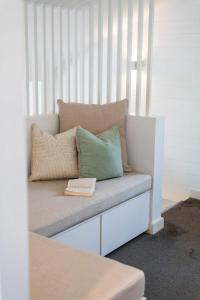 Bayshore Bungalow 13 - Oceanstays في خليج بايرون: مقعد به وسادتان وكتاب عليه +21 صورة