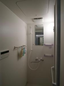 a bathroom with a shower with a mirror and a sink at 漫画のある家 in Wada