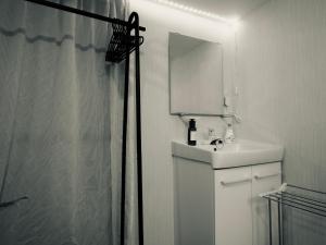 a white bathroom with a sink and a mirror at 漫画のある家 in Wada