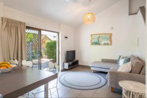 Bayshore Bungalow 14 - Oceanstays في خليج بايرون: غرفة معيشة بها أريكة وطاولة