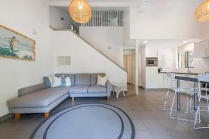 Bayshore Bungalow 14 - Oceanstays في خليج بايرون: غرفة معيشة مع أريكة ومطبخ