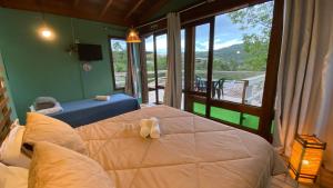 a bedroom with a bed and a large window at Pousada Sonho do Vale in Praia do Rosa +247 photos
