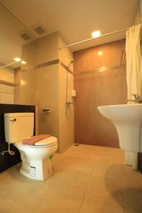 a bathroom with a toilet and a sink at Welnez World Residence Pattaya in Pattaya Central
