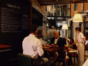 a group of people sitting at a table in a restaurant at Hotel Woolstore 1888, Sydney - Handwritten Collection in Sydney