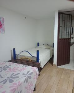 a bedroom with a bed next to a door at El Recuerdo de Paipa, Boyacá, Colombia in El Manzano