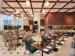 a restaurant with tables and chairs and a bar at Novotel New Delhi City Centre in New Delhi