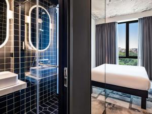 a bathroom with a bed and a glass shower at ibis Tbilisi City in Tbilisi City +57 photos
